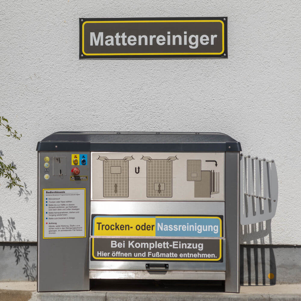 aufkleber-mattenreiniger-geraetekennzeichnung-0008968 Aufkleber Mattenreiniger erhöht angebracht an der Wand hinter dem Gerät zur Fernerkennung und Orientierung